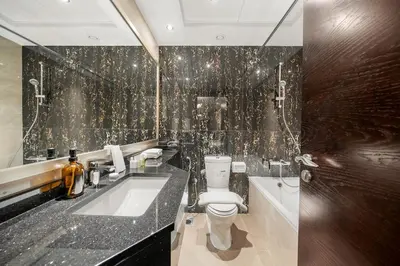 a bathroom with a toilet and a sink and a tub at FIRST CLASS 1BR Stylish , Modern Comfort in Dubai