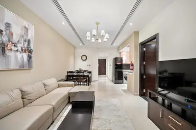 a living room with a couch and a dining room at FIRST CLASS 1BR Stylish , Modern Comfort in Dubai