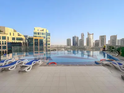 a view of a pool in a city with buildings at FIRST CLASS 1BR Stylish , Modern Comfort in Dubai
