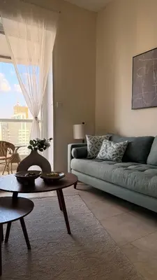 a living room with a blue couch and a table at Dar Al Noor Apartment in Dubai
