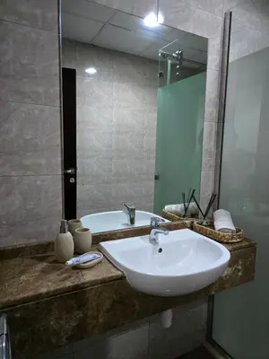 a bathroom with a sink and a tub and a mirror at Dar Al Noor Apartment in Dubai