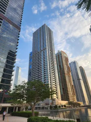 a city skyline with tall buildings and a tree at Dar Al Noor Apartment in Dubai