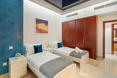 a bedroom with two beds and a cabinet at Luxe 3BR and Maid Room with Panoramic Dubai Eye View - JBR Beach in Dubai