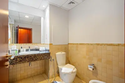 a bathroom with a toilet and a sink and a mirror at Luxe 3BR and Maid Room with Panoramic Dubai Eye View - JBR Beach in Dubai