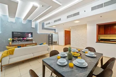 a living room with a table and a couch at Luxe 3BR and Maid Room with Panoramic Dubai Eye View - JBR Beach in Dubai