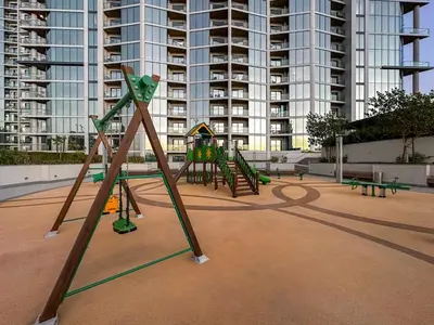 a playground in front of a large building at FIRST CLASS 2BR Luxury Living at Waves Grande in Dubai