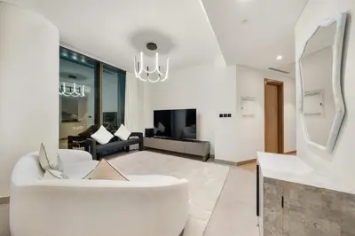a living room with a white couch and a fireplace at FIRST CLASS 2BR Luxury Living at Waves Grande in Dubai
