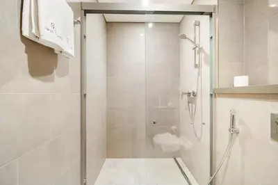 a shower with a glass door in a bathroom at FIRST CLASS 2BR Luxury Living at Waves Grande in Dubai
