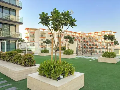 a courtyard with palm trees and a building at FIRST CLASS 1BR Minimalist Elegance in Dubai