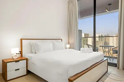 a bedroom with a white bed and a large window at FIRST CLASS 1BR Minimalist Elegance in Dubai