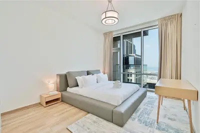 a bedroom with a bed and a large window at Premium 3-BR Serene Canal View High Floor in Dubai