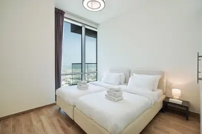 two beds in a room with a large window at Premium 3-BR Serene Canal View High Floor in Dubai