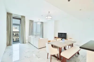 a living room with a table and chairs and a television at Premium 3-BR Serene Canal View High Floor in Dubai