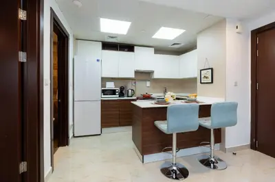 a kitchen with a counter and two chairs in it at Peaceful - Charming - Urban Hideaway in Dubai