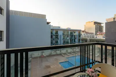 a balcony with a view of a pool and buildings at Peaceful - Charming - Urban Hideaway in Dubai
