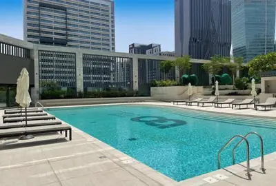 a large swimming pool with benches and buildings at Chic 1-Bedroom Retreat in Heart of Business Bay in Dubai