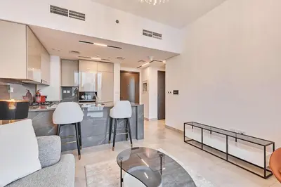 a kitchen and living room with a couch and a table at Chic 1-Bedroom Retreat in Heart of Business Bay in Dubai