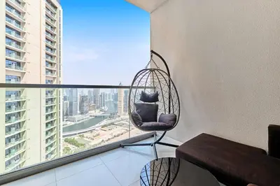 a rattan chair in a room with a window at Luxury 2BR with Skyline Views Prime Business Bay Location in Dubai
