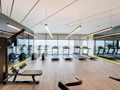 a gym with a row of treadmills and machines at Luxury 2BR with Skyline Views Prime Business Bay Location in Dubai
