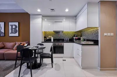 a kitchen and living room with a couch and a table at Luxury 2BR with Skyline Views Prime Business Bay Location in Dubai