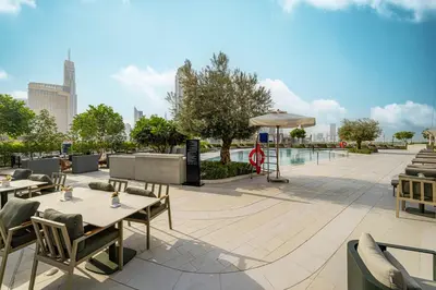 a patio with tables and chairs and an umbrella at Vida Dubai Mall! Excellent Amenities, Mall Connected! in Dubai