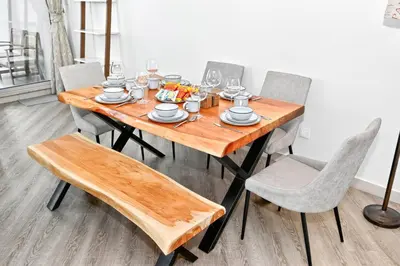 a wooden table with chairs and a plate of food on it at Torch Dubai Marina 2BDR with Pool Gym and Views in Dubai