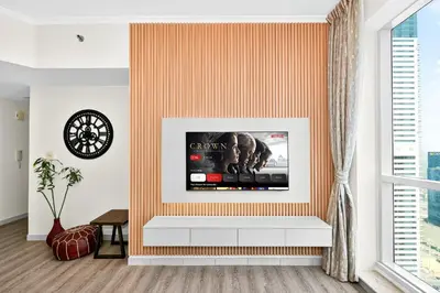 a living room with a tv on a wall at Torch Dubai Marina 2BDR with Pool Gym and Views in Dubai