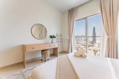 a bedroom with two beds and a desk with a window at Iconic Burj Khalifa View 2BR with Assistant Room, Steps from Dubai Mall and Beside a Park, Bellevue Towers 1, Downtown Dubai by Deluxe Holiday Homes in Dubai