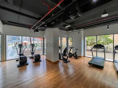 a gym with several treadmills and elliptical machines at Iconic Burj Khalifa View 2BR with Assistant Room, Steps from Dubai Mall and Beside a Park, Bellevue Towers 1, Downtown Dubai by Deluxe Holiday Homes in Dubai