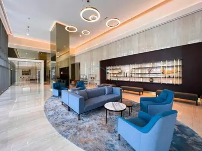 a hotel lobby with blue couches and a rug at Iconic Burj Khalifa View 2BR with Assistant Room, Steps from Dubai Mall and Beside a Park, Bellevue Towers 1, Downtown Dubai by Deluxe Holiday Homes in Dubai