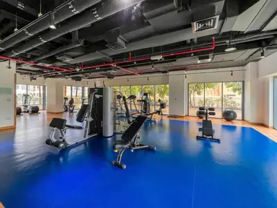 a gym with a blue gym floor with treadmills at Iconic Burj Khalifa View 2BR with Assistant Room, Steps from Dubai Mall and Beside a Park, Bellevue Towers 1, Downtown Dubai by Deluxe Holiday Homes in Dubai