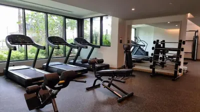 a gym with several tread machines and a mirror at Luxury 1BR in Central Business Bay in Dubai