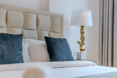 a bedroom with a bed with blue pillows and a lamp at TRPS - Bluewaters Residence 3, Bluewaters Island - Ain Dubai View, Fully Furnished, Close to JBR and Marina in Dubai