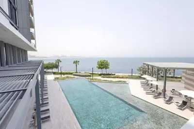 a swimming pool with chairs and the ocean in the background at TRPS - Bluewaters Residence 3, Bluewaters Island - Ain Dubai View, Fully Furnished, Close to JBR and Marina in Dubai