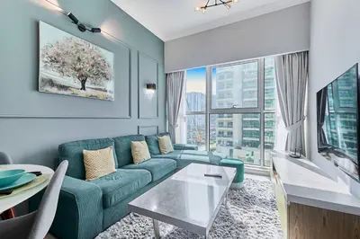 a living room with a blue couch and a table at Luxury 1BHK with Stunning Canal View Business Bay in Dubai