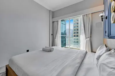 a bedroom with a large bed and a large window at Luxury 1BHK with Stunning Canal View Business Bay in Dubai