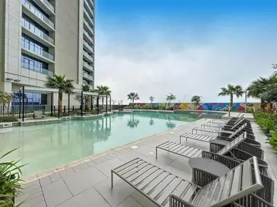 a swimming pool with chaise lounge chairs in a building at Elegant 2BR Apartment Heart of Business Bay High Floor in Dubai