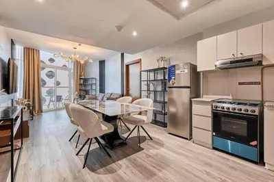 a kitchen with a table and chairs and a refrigerator at Millennium Heights 1 in Dubai