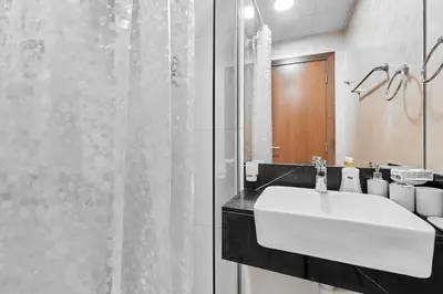 a bathroom with a white sink and a shower at Millennium Heights 1 in Dubai