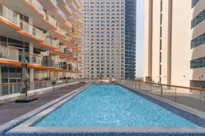 a large swimming pool in a building with tall buildings at Millennium Heights 1 in Dubai