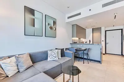 a living room with a couch and a kitchen at Khalifa View Luxe 1BHK in Dubai