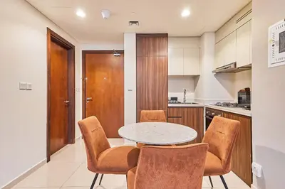 a kitchen with a table and chairs in a room at Cityscape Comforts 2BR in Dubai