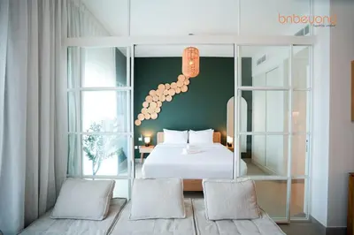 a bedroom with a white bed and two chairs at Nomad Haven with Pvt Cinema and C0-working Space in Dubai