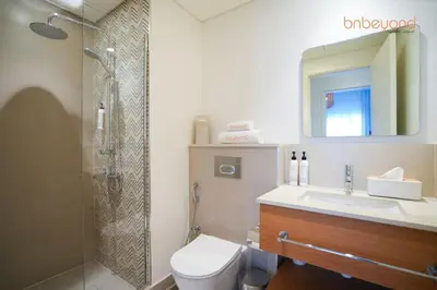 a bathroom with a shower and a toilet and a sink at Nomad Haven with Pvt Cinema and C0-working Space in Dubai