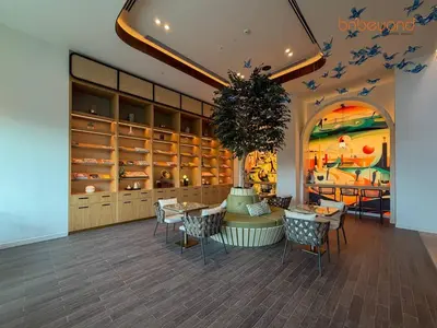a restaurant with tables and chairs in a room with a painting at Nomad Haven with Pvt Cinema and C0-working Space in Dubai