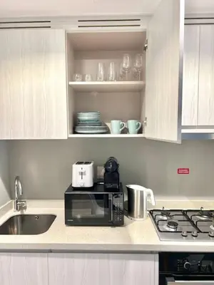 a kitchen counter with a microwave and a sink at Cozy 1BR in Zada Tower Business Bay in Dubai