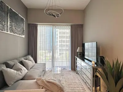 a living room with a couch and a television at Cozy 1BR in Zada Tower Business Bay in Dubai