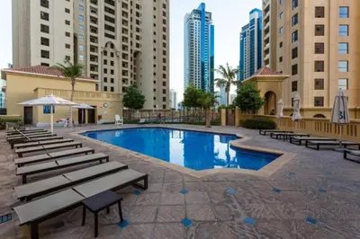 a large swimming pool with benches and buildings at Vacationer I Luxury 2 Bedroom Apartment I Marina View I Steps from JBR Beach in Dubai