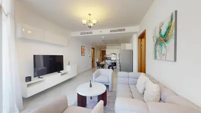 a living room with a white couch and a tv at Vacationer l 1 Bedroom Perched on the 19th Floor l Free Pool, Gym Access in Dubai