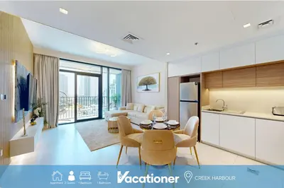 a kitchen and living room with a couch and a table at Vacationer l Stunning 1 Bedroom l City View l Pool, Gym Access in Dubai